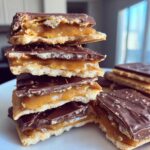 A stack of rich Caramel Ritz Cracker Christmas Cookies showing layers of crackers, gooey caramel, and melted chocolate topping.