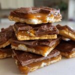 A stack of rich Caramel Ritz Cracker Christmas Cookies featuring a cracker base, gooey caramel, and chocolate topping.