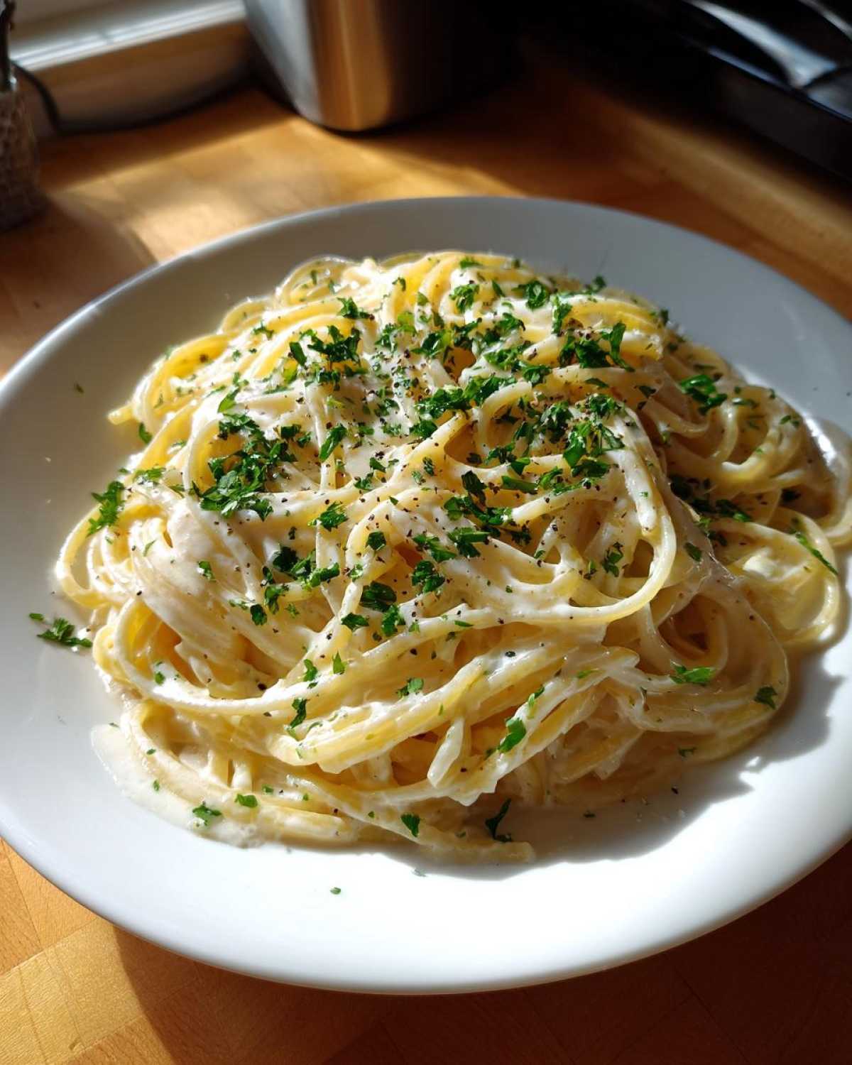 A plate of delicious Creamy Lemon Pasta tossed in a rich sauce and topped with fresh parsley and black pepper.
