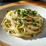 A close-up of a generous serving of Creamy Lemon Pasta tossed in a rich sauce and topped with fresh chopped parsley.