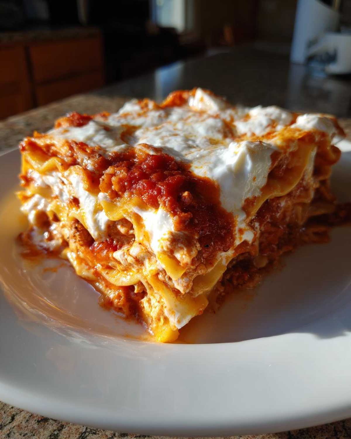 A generous slice of layered instant pot lasagna topped with rich tomato sauce and creamy white ricotta cheese.