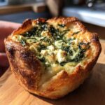 Close-up of a golden-brown Mediterranean Spinach and Feta Cheese Crisp with visible spinach and feta filling.