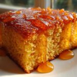 Close-up of a slice of moist sourdough cornbread generously drizzled with golden honey.