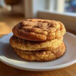 A stack of three soft, thick applesauce cookies generously coated in cinnamon sugar.
