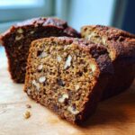 A close-up, tasty shot of sliced date nut bread showing the moist interior packed with walnuts and dates.