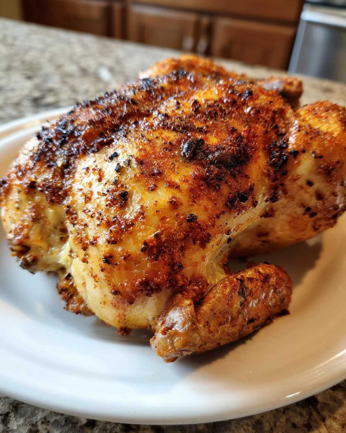 Close-up of a perfectly cooked air fryer whole chicken with crispy, seasoned, golden-brown skin.