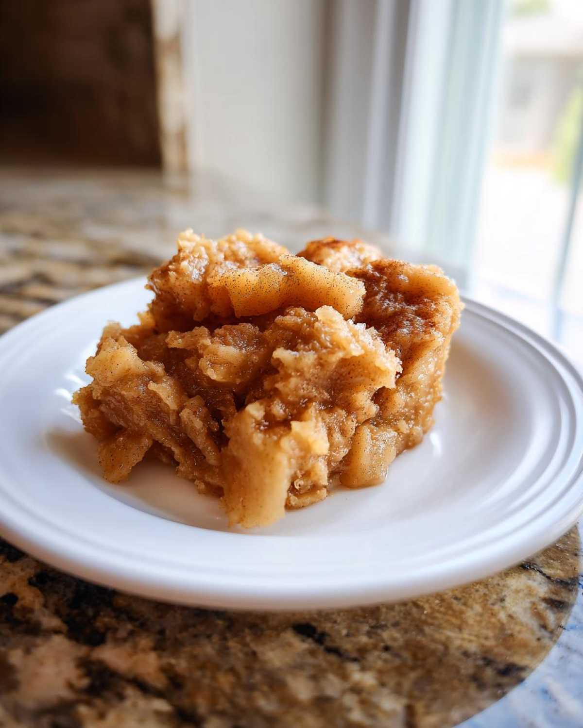 Close-up of a serving of chunky, spiced applesauce on a white plate, ready to eat.