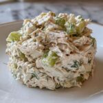 A perfectly molded scoop of creamy cottage cheese chicken salad mixed with crisp celery chunks and fresh dill.