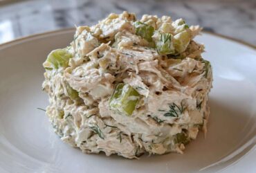 A perfectly molded scoop of creamy cottage cheese chicken salad mixed with crisp celery chunks and fresh dill.