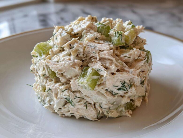 A perfectly molded scoop of creamy cottage cheese chicken salad mixed with crisp celery chunks and fresh dill.