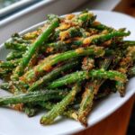 Close-up of bright green beans coated in crispy, golden brown Parmesan breading.