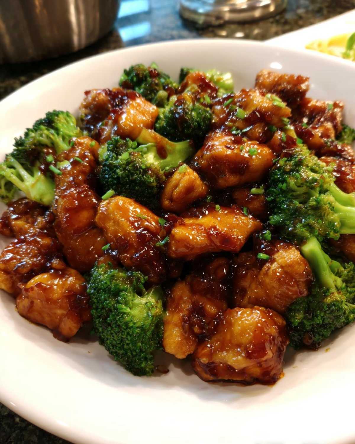 Close-up of saucy, glazed chicken and bright green broccoli florets, a perfect chicken and broccoli dinner.