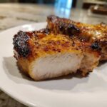 Cross-section of a perfectly cooked, juicy pork chop showing a caramelized crust from the marinade for pork chops.