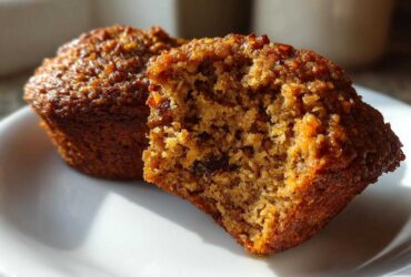 Close-up of a bran muffin cut in half showing its moist, textured interior and raisins.