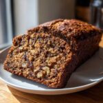 Close-up of a moist slice of date nut bread showing visible dates and walnuts.