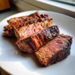 Slices of medium-rare steak showing a beautiful sear, achieved using the carne asada marinade.