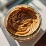 Overhead view of creamy peanut butter swirled inside a glass jar, perfect for Vegan Peanut Butter Banana Overnight Oats.