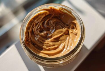 Overhead view of creamy peanut butter swirled inside a glass jar, perfect for Vegan Peanut Butter Banana Overnight Oats.