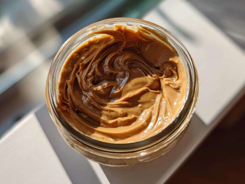 Overhead view of creamy peanut butter swirled inside a glass jar, perfect for Vegan Peanut Butter Banana Overnight Oats.