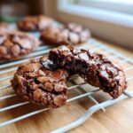 Close-up of a Gluten-Free Chocolate Mint Cookie broken in half showing a gooey, melted chocolate center.