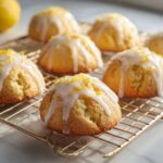 Close-up of several domed Gluten-Free Lemon Ricotta Cookies drizzled with white icing and lemon zest.
