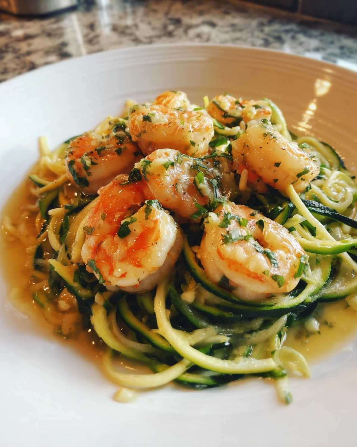 Close-up of Keto Shrimp Scampi Zucchini Noodles served in a white bowl with a buttery garlic sauce.