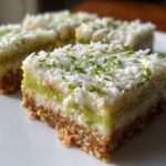 A close-up of a square No-Bake Coconut Lime Bars piece showing the graham cracker crust and coconut topping.