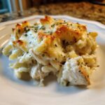 A close-up serving of Cheesy Chicken Alfredo Bake with Mozzarella, featuring pasta, chicken, and a golden, bubbly cheese topping.