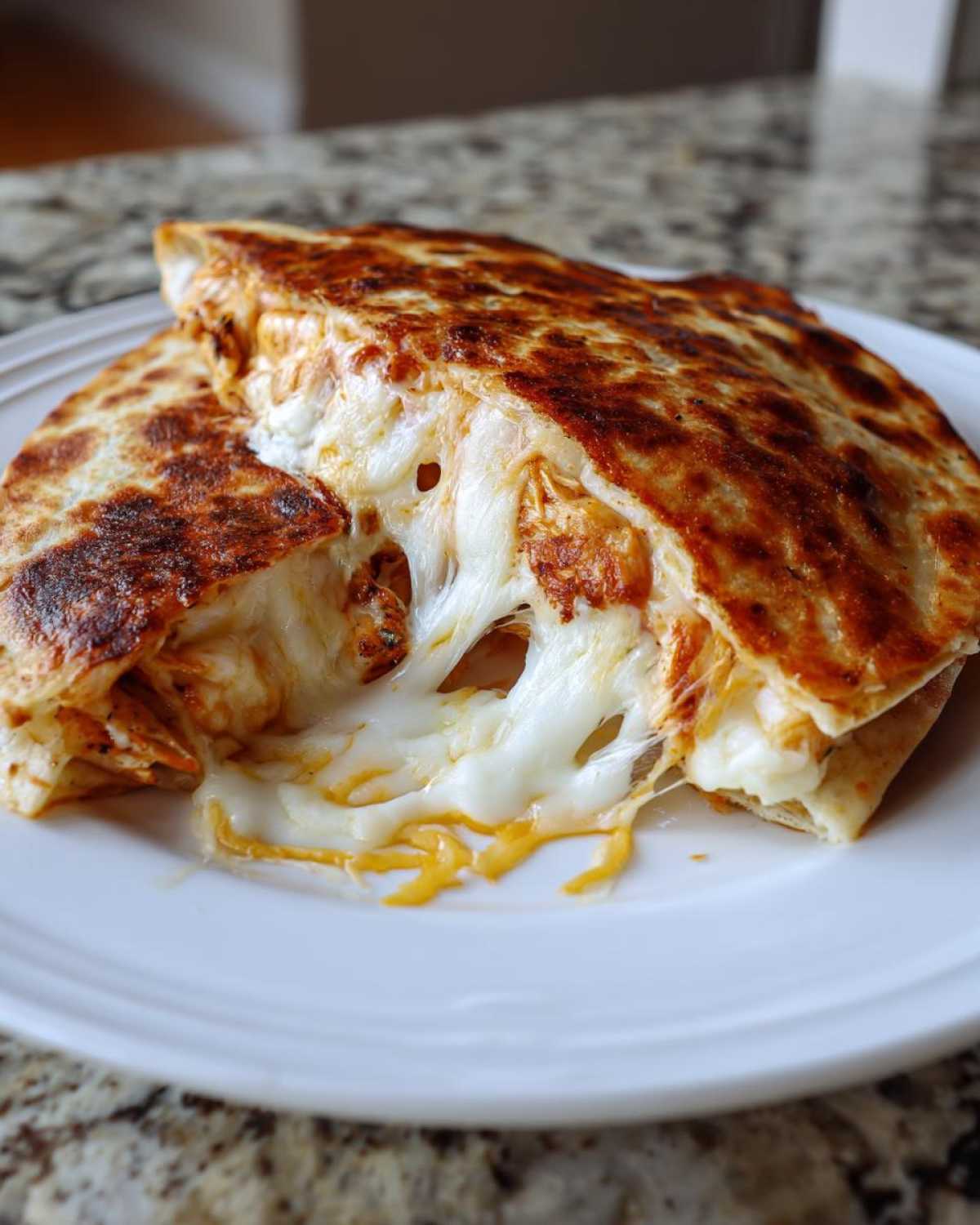 Close-up of a Cheesy Chicken Quesadilla with Crispy Tortilla, showing an extreme cheese pull.