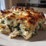 A generous serving of Cheesy Chicken and Spinach Bake Comfort Meal with a golden, bubbly cheese crust.