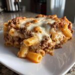 Close-up of a hearty slice of Cheesy Ground Beef Pasta Bake with Creamy Sauce, topped with melted mozzarella.
