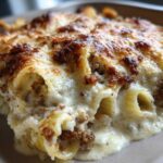 Close-up of baked Cheesy Ground Beef Stuffed Shells with Cream Sauce, featuring a golden-brown, bubbly cheese topping.