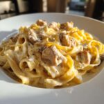 A close-up shot of fettuccine noodles coated in rich sauce and topped with chunks of chicken in our Creamy Alfredo Chicken Pasta Easy Recipe.