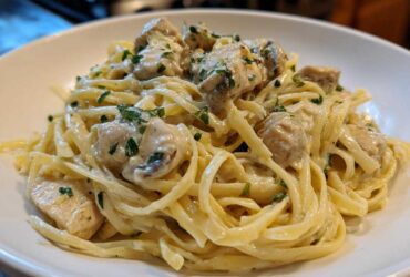 Close-up of fettuccine pasta coated in rich sauce with chunks of chicken, part of the Creamy Alfredo Chicken Pasta Easy Recipe.