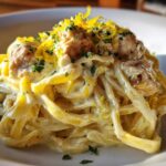 A close-up of Creamy Lemon Garlic Pasta with Chicken, tossed in a rich sauce and topped with lemon zest and parsley.
