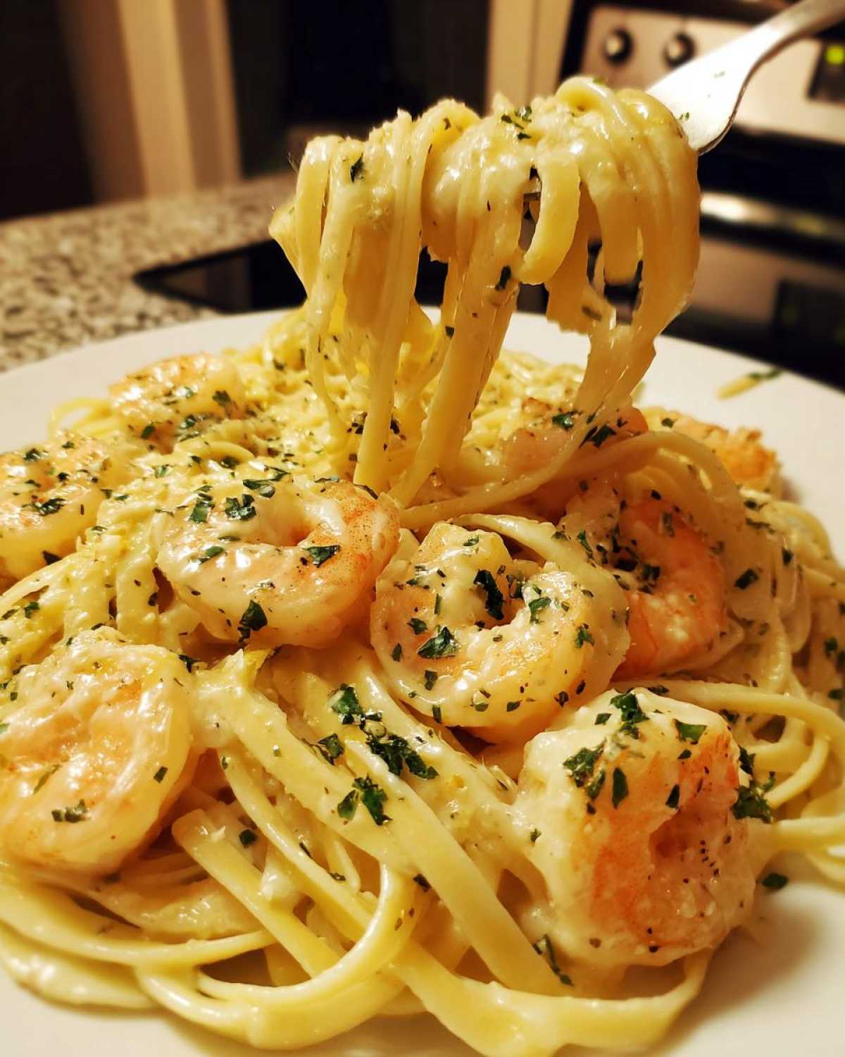 Close-up of Creamy Lemon Garlic Shrimp Pasta with fettuccine noodles and large shrimp, garnished with parsley.