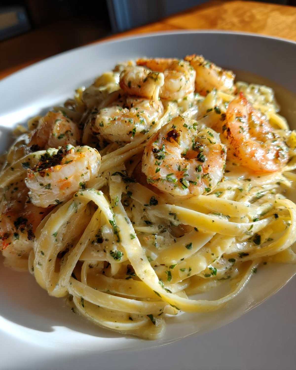 Close-up of creamy lemon garlic shrimp pasta featuring fettuccine coated in a rich sauce and topped with seasoned shrimp and parsley.
