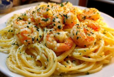 Close-up of a plate of Creamy Lemon Garlic Shrimp Pasta, topped with plump shrimp and fresh parsley.