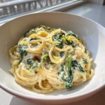 A close-up of Creamy Lemon Ricotta Pasta with Spinach tossed in a rich sauce and topped with lemon zest.