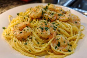 Close-up of Creamy Lemon Shrimp Pasta topped with sautéed shrimp and fresh parsley.