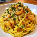 Close-up of a bowl of Creamy Lemon Shrimp Pasta Fresh Flavor topped with sautéed shrimp and fresh parsley.