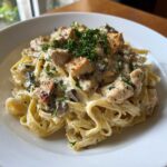 Close-up of rich Creamy Mushroom Chicken Alfredo Pasta tossed with fettuccine and garnished with fresh parsley.
