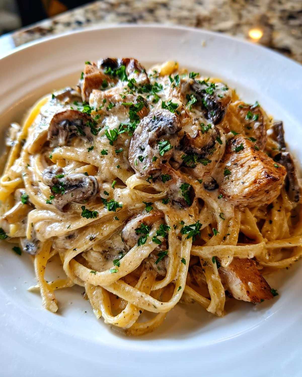 Close-up of rich Creamy Mushroom Chicken Pasta with Garlic Sauce, topped with fresh parsley.