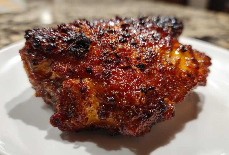 Close-up of a perfectly cooked Honey Garlic Chicken Thighs with dark, glossy, and crispy skin.