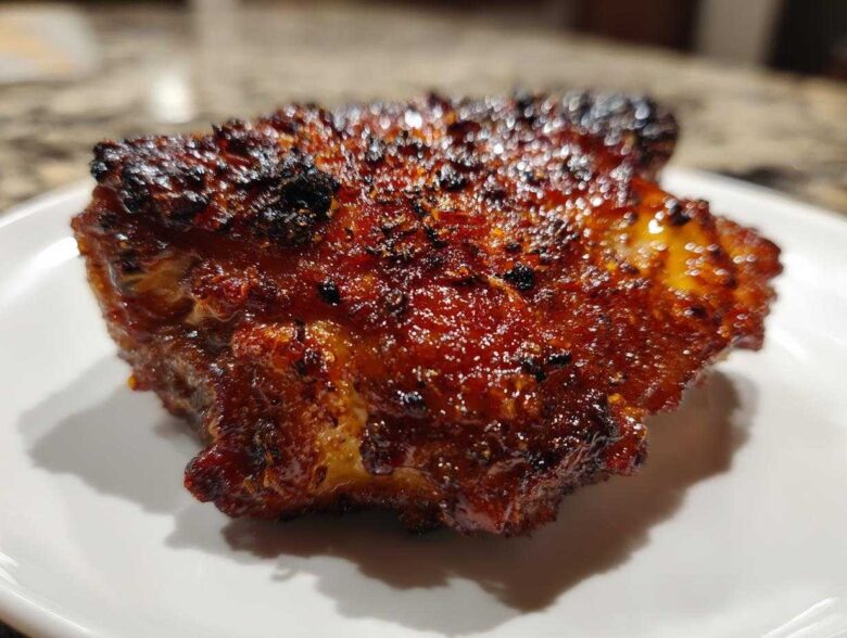 Close-up of a perfectly cooked Honey Garlic Chicken Thighs with dark, glossy, and crispy skin.