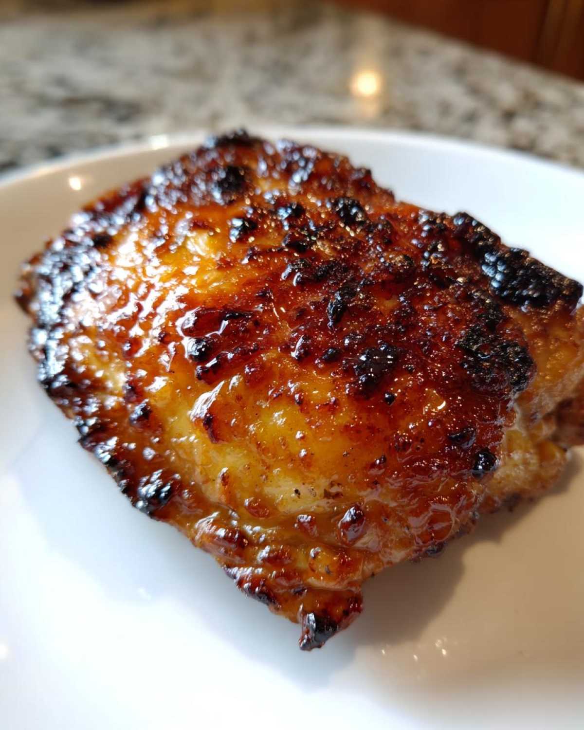 Close-up of a perfectly cooked Honey Garlic Chicken Thighs with incredibly crispy, glazed, and caramelized skin.