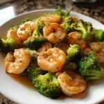 Close-up of Garlic Butter Shrimp and Broccoli Skillet served on a white plate with visible garlic butter sauce.