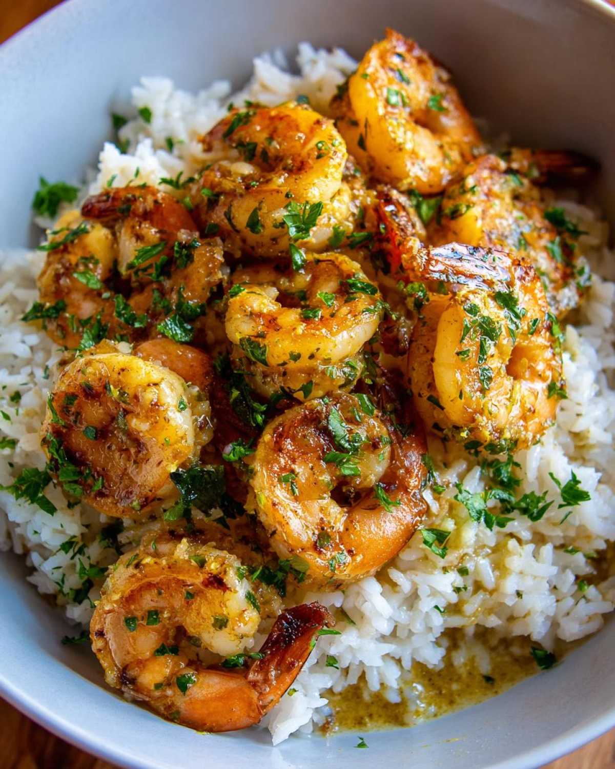 Close-up of a Garlic Butter Shrimp Bowl with Rice, featuring plump, seasoned shrimp over white rice, topped with fresh parsley.