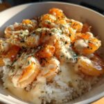 Close-up of a Garlic Butter Shrimp Rice Bowl topped with creamy garlic sauce and parsley.
