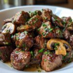 Close-up of juicy Garlic Butter Steak Bites with Mushrooms, glistening in sauce and topped with fresh parsley.
